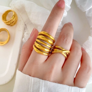Detail of layered spiral and cross-over 18K gold plated titanium rings on a model