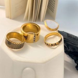 Set of four 18K gold plated titanium rings with black enamel and shell inlay details