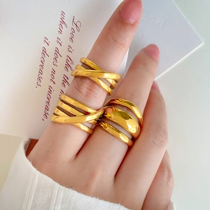 Multilayer crisscross 18K gold plated titanium rings on hand with minimalist aesthetic
