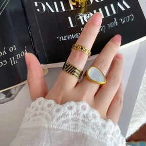 Detailed view of vintage gold-plated rings with black enamel and white shell inlay