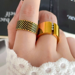 Detail of 18K gold-plated wide rings with black chevron enamel and micro silver bead accents