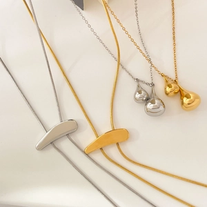 Minimalist 18K gold and silver snake chain necklaces with liquid metal teardrop pendants