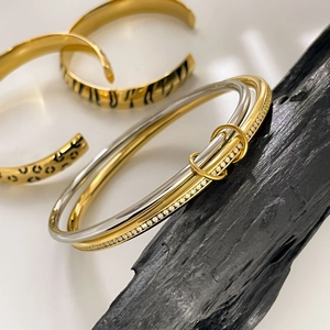 Detailed view of dual-tone pavé crystal bangle with gold leopard print textured bracelets