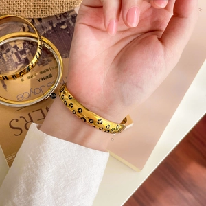 Detail of 18K gold plated leopard print double ring bangle with crystal accents