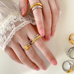Élégant ensemble de bagues en titane bicolore or et argent avec perles et zircon sur la main