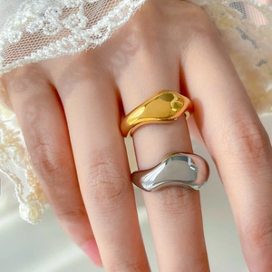 Vue détaillée de bagues superposées en or et argent avec perles sur la main du mannequin