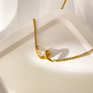 Macro view of pear-cut zircon pendant on an 18K gold plated stainless steel snake chain