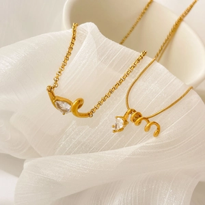 Detail of gold snake and link chains with spiral pendants and pear-cut cubic zirconia