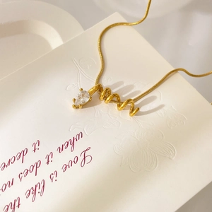 Detail of 18K gold-plated necklace featuring spiral pendant with teardrop zircon stone
