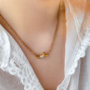 Close-up of 18K gold plated necklace with marquise zircon pendant on model neck