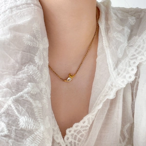Detail of 18K gold-plated twisted snake chain with a pear-cut zircon pendant on neck