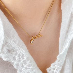 Detail of 18K gold plated snake chain with spiral pendant and pear-cut zircon on collarbone