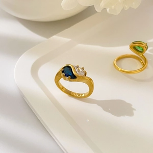 Détail de bagues plaquées or 18 carats avec des zircons bleus et verts en forme de goutte