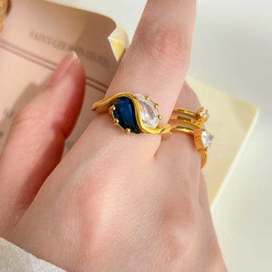 Gros plan d'une bague en or 18 carats avec zircons bicolores portee par un modele