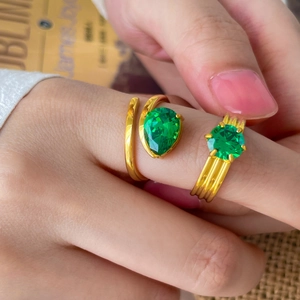 Détail macro de bagues plaquées or 18 carats avec zircons verts et rouges en goutte