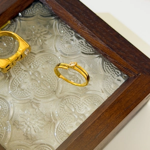 Detailed close-up of 18K gold plated ring with marquise zircon on a vintage glass surface