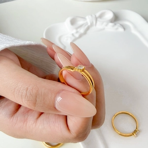 Close-up of three 18K gold plated stackable rings with tiny zircon crystals on hands