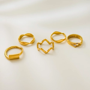 Close-up of five-piece 18K gold plated wavy rings with layered and twisted stackable designs