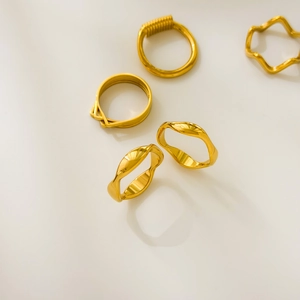 Detail of 18K gold plated titanium rings featuring wavy and layered geometric designs
