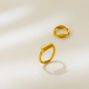 Detailed view of polished 18K gold plated wavy and textured stacking ring set