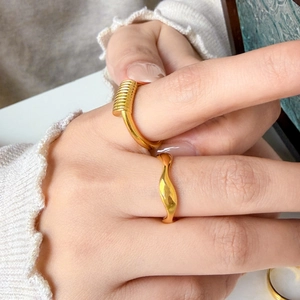 Detail of 18K gold-plated titanium steel wavy rings and coiled multi-line stack rings