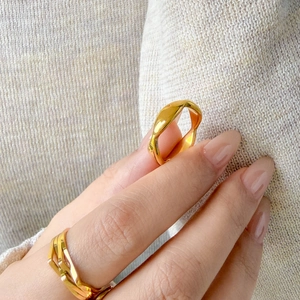 Detail of 18K gold plated wavy and multi-layer titanium steel rings on model hand