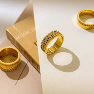 Détail de trois bagues en titane plaqué or 18 carats avec pavé de cristaux de zircon