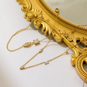 Collier en or 18 carats avec pendentifs en zircon aux formes variées sur fond blanc
