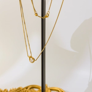 Détail du collier à mailles carrées dorées avec pendentif goutte en zircone cubique