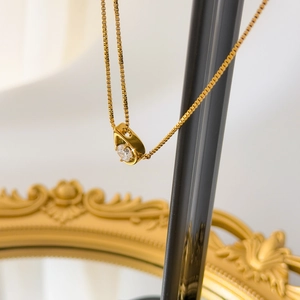 Détail d'un collier goutte d'or avec un pendentif serti d'un oxyde de zirconium rond