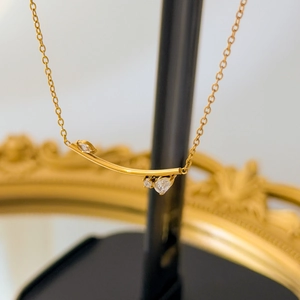 Vue détaillée de la chaîne en or 18k avec barre incurvée et pendentifs en zircon brillant