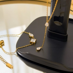 Collier en or 18 carats avec pendentifs zircons gouttes et carrés sur support noir