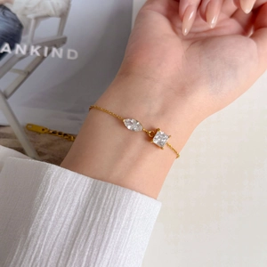 Détail d'un bracelet doré avec oxydes de zirconium tailles marquise et princesse