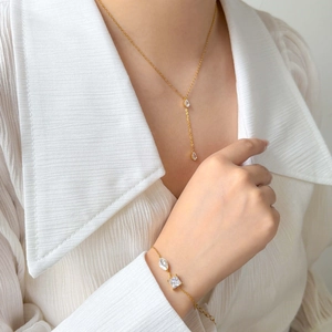 Détail du collier à pendentif goutte en zircon et bracelet assorti sur un modèle