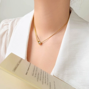 Gros plan détaillé d'un collier goutte d'eau en or 18 carats avec zircon sur un mannequin