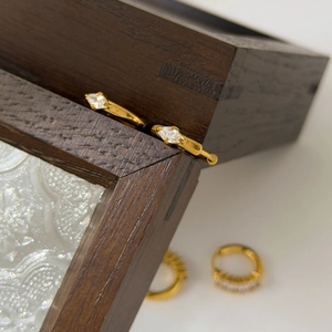 Detailed view of 18K gold plated hoop earrings with channel-set white cubic zirconia stones