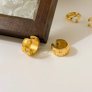 Detail of 18K gold plated titanium hoop earrings with sparkling cubic zirconia inlay