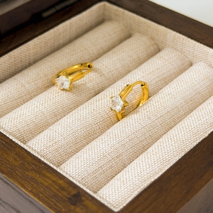 Close-up of gold plated star zircon hoop earrings in a premium wooden jewelry box