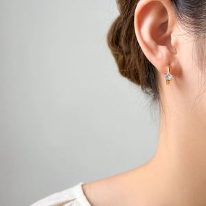 Macro shot of 18K gold plated hoop earring featuring a brilliant star-cut zircon stone