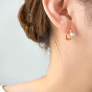 Close-up of a model wearing a 18K gold-plated titanium steel hoop with a heart zircon