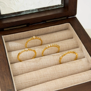 Detailed view of four 18K gold plated stackable rings with delicate micro diamonds set in wood