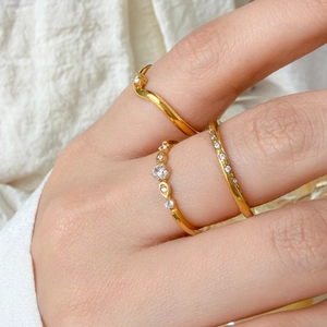 Detailed view of three stacked 18K gold plated rings with paved cubic zirconia stones
