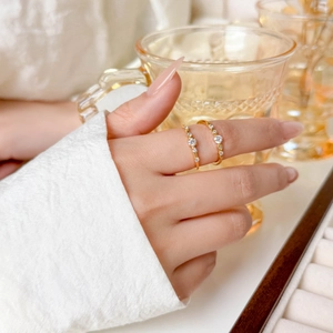 Close-up of two slim 18K gold plated titanium steel rings with pavé micro-zirconia