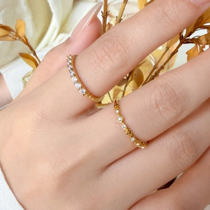 Macro view of stackable 18K gold plated titanium rings with delicate micro pavé diamonds