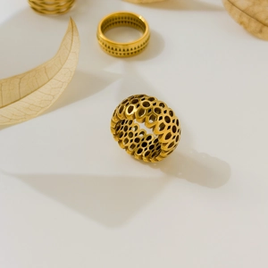 Detailed view of honeycomb perforated 18K gold plated stainless steel ring set