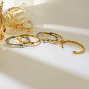 Polished 18K gold and silver teardrop zircon bangles in open and closed minimalist styles