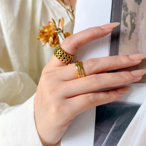 Detail of 18K gold plated honeycomb and geometric triangle rings set worn by model