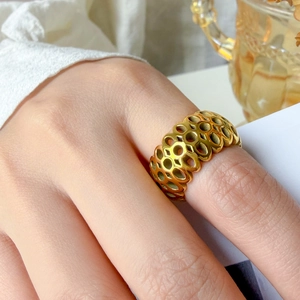 Detail view of 18K gold plated wide ring with hollow geometric circular patterns