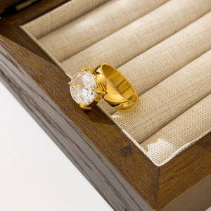 Detailed view of an 18K gold-plated ring with a large zircon in a wooden box