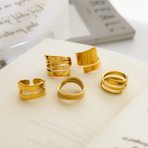 Five gold-plated titanium steel rings featuring layered spirals and a polished mirror finish